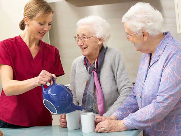 Nurse serving tea in the memory care unit